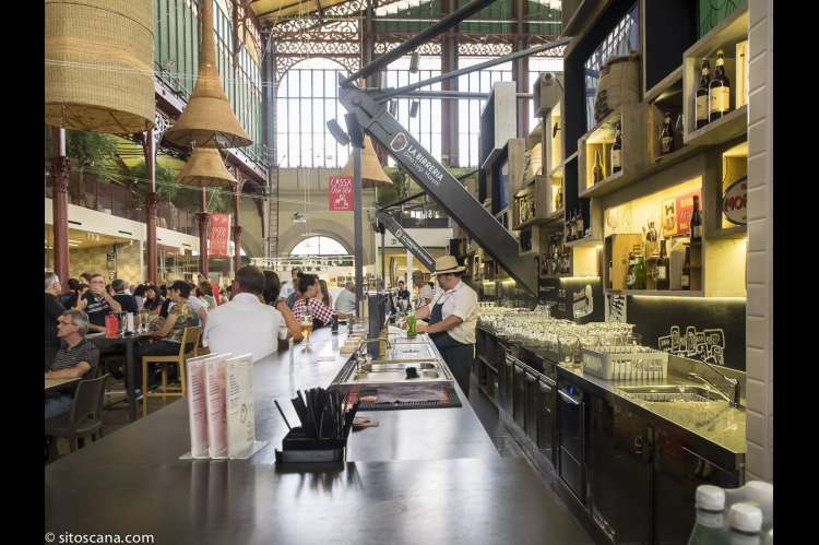 Bildet viser servitør som tapper øl og kunder ved en bar i Matmarkedet i Firenze – Mercato Centrale