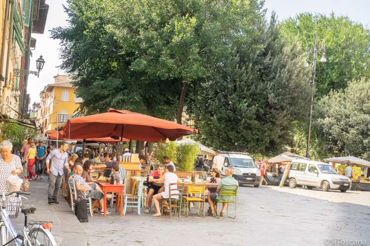 Bildet viser en av de små spisestedene og litt av torget på Piazza Santo Spirito i Firenze. Toscana, Italia.