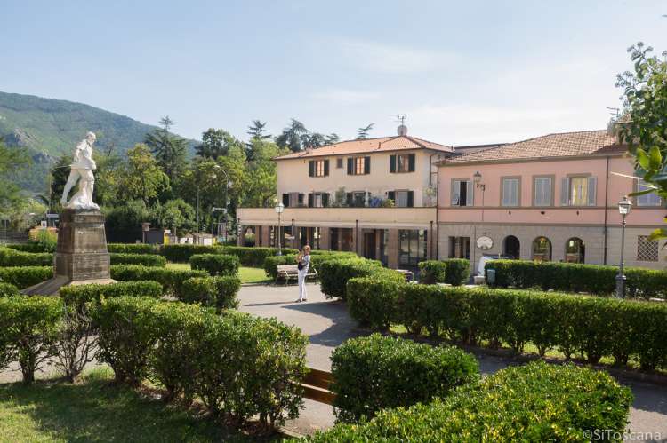 Bildet viser en kvinne som fotograferer statuen som står i parken utenfor kommunehuset i landsbyen Calci., Pisa, Toscana, Italia.