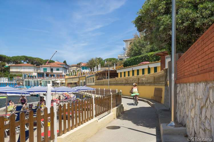 Bildet viser dame på sykkel ved sjøen i badebyen Castiglioncello sør for Pisa i Toscana.