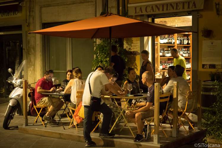 Bildet viser folk som sitter ute på en vinbar i sentrum av Pisa. Det er sommer og kveld.