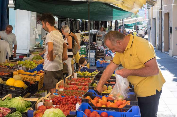 Bildet viser mann som handler frukt og grønnsaker på markedet i Calci.