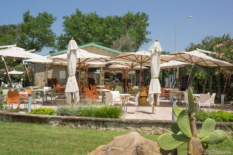 Bildet viser spisestedet som ligger rett ved bilettluka på badelandet Sunlight Park. Uteservering i grønne omgivelser med store parasoller.