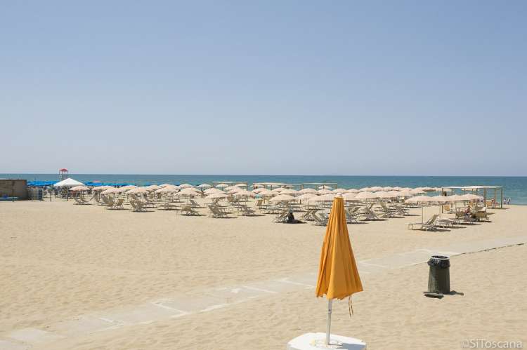 Bildet viser spiaggia attrezzata, det vil si utstyrt med solstoler og parasoller, på Spiaggia Verruca i badebyen Tirrenia.