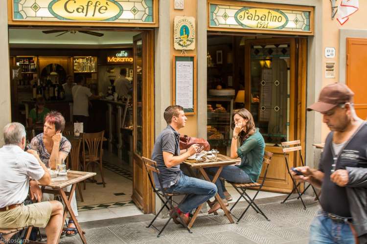 Bildet viser et pas som sitter ved et bord utenfor en bar i Firenze. I Toscana i Italia.