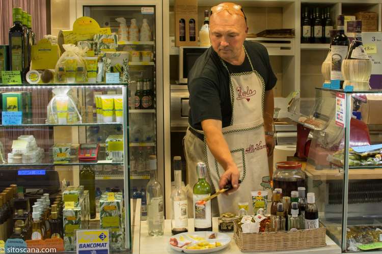 Bildet viser forhandler som gjør klar smaksprøver i Matmarkedet i Firenze – Mercato Centrale