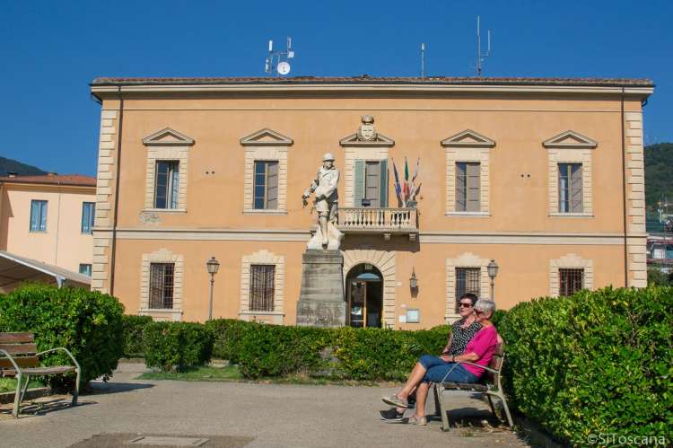 Bildet viser to kvinner på en benk foran kommunehuset i Calci, like utenfor Pisa i Toscana.