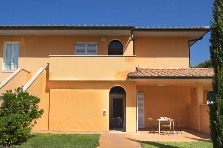 Bildet viser gult hus med uteplass til en av leilighetene på Vicino Mare. Gangavstand til strand og landsby, sør i Toscana.