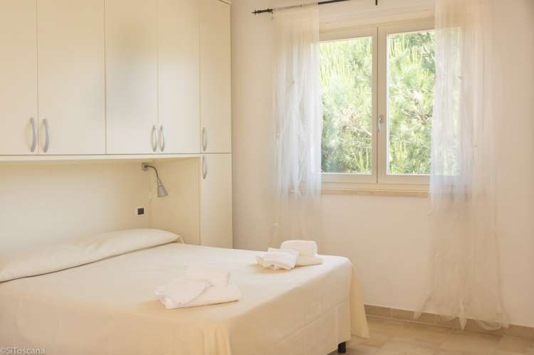 Bildet viser soverom i en av ferieleilighetene på Vicino Mare ved kysten sør i Toscana.