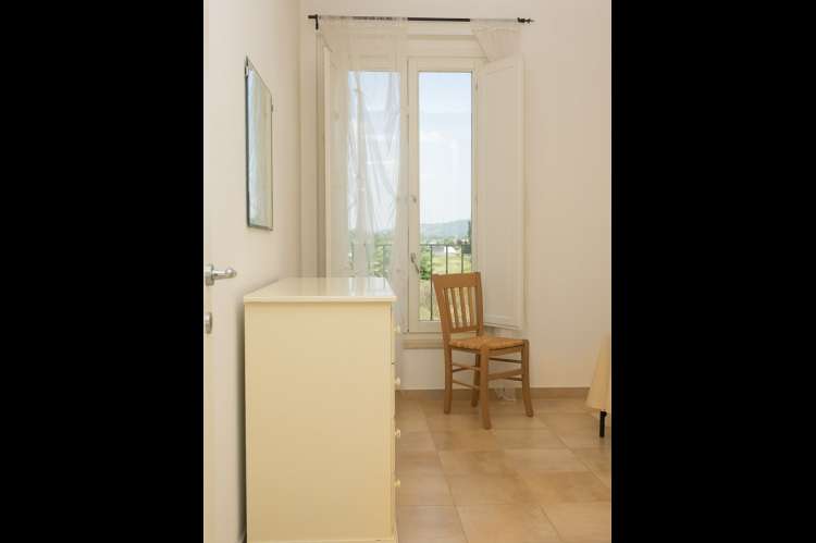 Bildet viser soverom til en av ferieleilighetene på Vicino Mare. Med barnebasseng sør i Toscana.