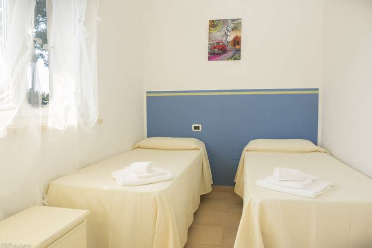 Bildet viser et av soverommene med to enkeltsenger på Vicino Mare, med utsikt. 