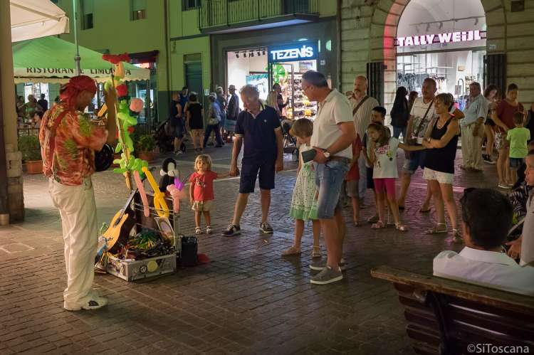 Bildet viser barn i handlegata i badebyen Follonica på kvelden.