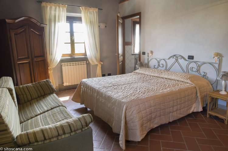 Foto av sofa og dobbeltseng i ferieleiligheten Melograno.