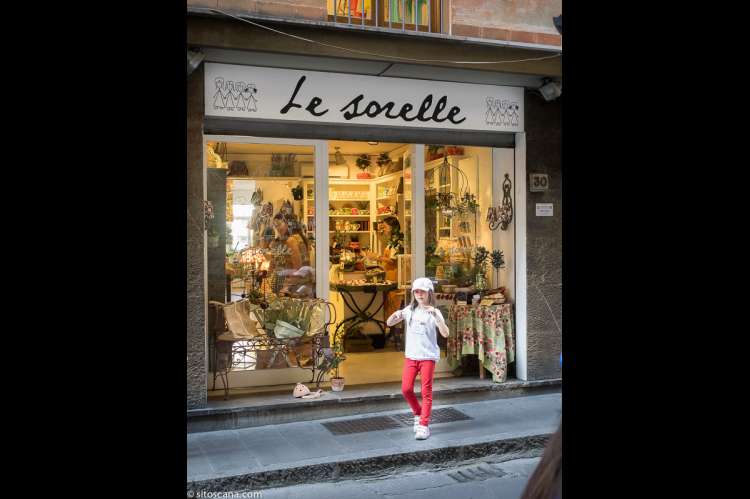 Jente som står på fortauet utenfor en butikk. I shoppingstrøket i nærområdet til ferieleiligheten Marco i sentrum av Firenze. Foto.