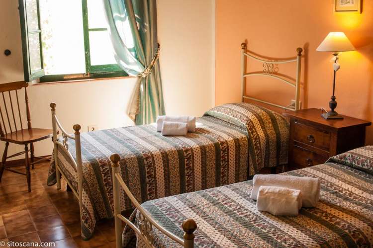 Bildet viser soverom med enkeltsenger i leiligheten Melograno på feriebostedet Girasole, vingård med 10 leiligheter og gangavstand til landsby.