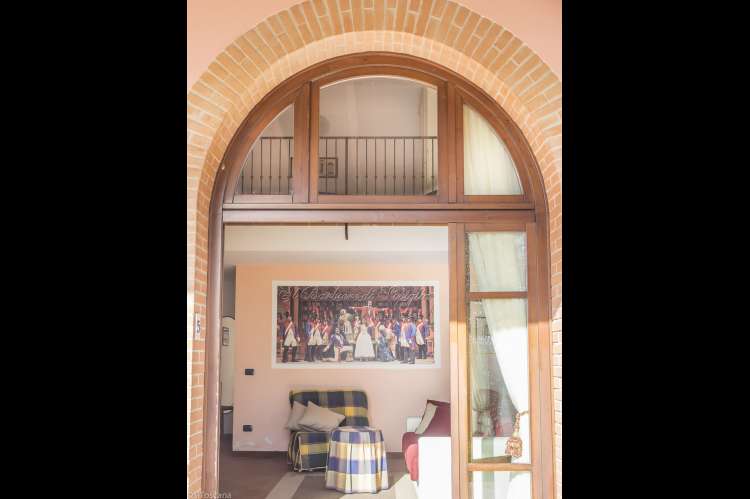 Ni av suitene har oppholdsrom og bad i 1. etg og soverom på hems. Suite med inngangsdør, deler av oppholdsrom og soverom på vingården Podere Cenni ved San Miniato. Foto.