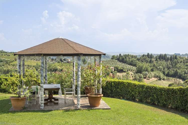 Flott utsikt mot vinmarker, olivenlunder og åsene rundt gården. Lysthus med utsikt mot vinmarker og olivenlunder på vingården Podere Cenni utenfor San Miniato. Foto.