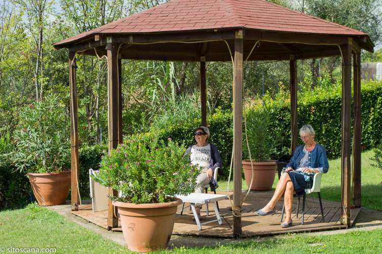 Vingården egner seg godt for store og små. To kvinner som slapper av i skyggen i lysthuset på vingården Podere Cenni utenfor San Miniato. Foto.