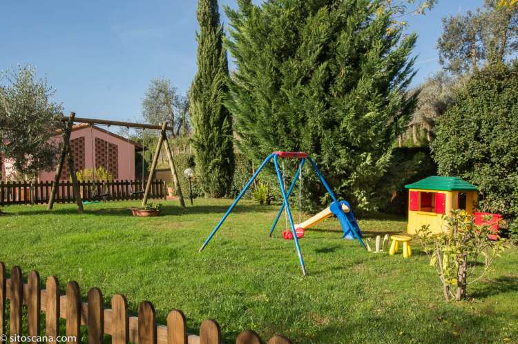 Inngjerdet lekeplass mellom husene. Inngjerdet lekeplass på vingården Podere Cenni utenfor San Miniato. Foto.