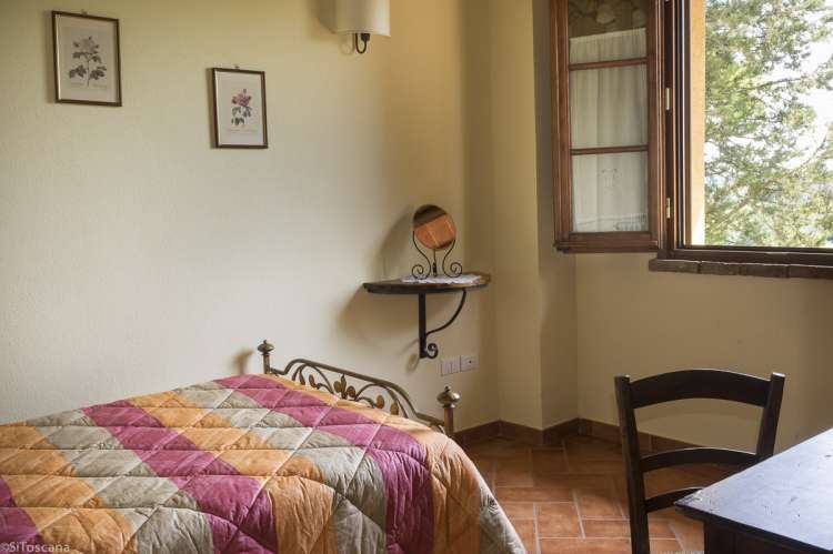 Lucciola har tre soverom. Bilde fra et av soverommene i ferieleiligheten Lucciola. Vindu mot landskapet i Toscana.