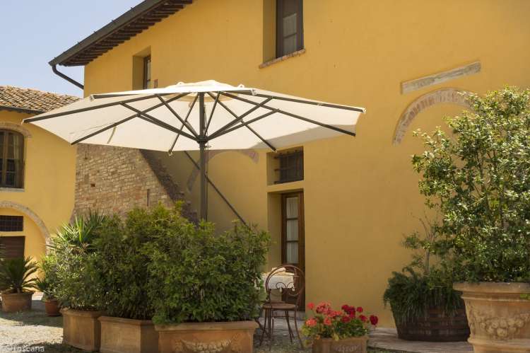 Lucciola ha uteplass på bakkeplan. Trappa opp til leiligheten bak. Bilde fra uteplassen til ferieleiligheten Lucciola. Omgitt av planter i krukker.