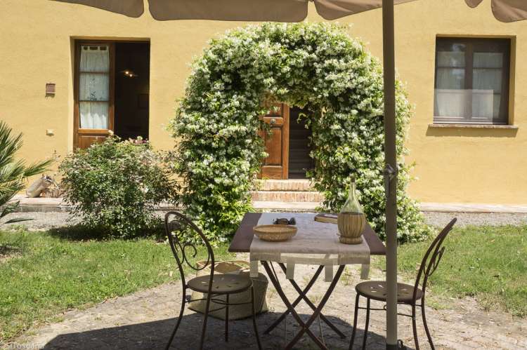 La Bella Lavanderina har rommelig uteplass. Foto av uteplassen til ferieleilighet på vingård i Toscana. La Bella Lavanderina med portal av blomster i hagen.
