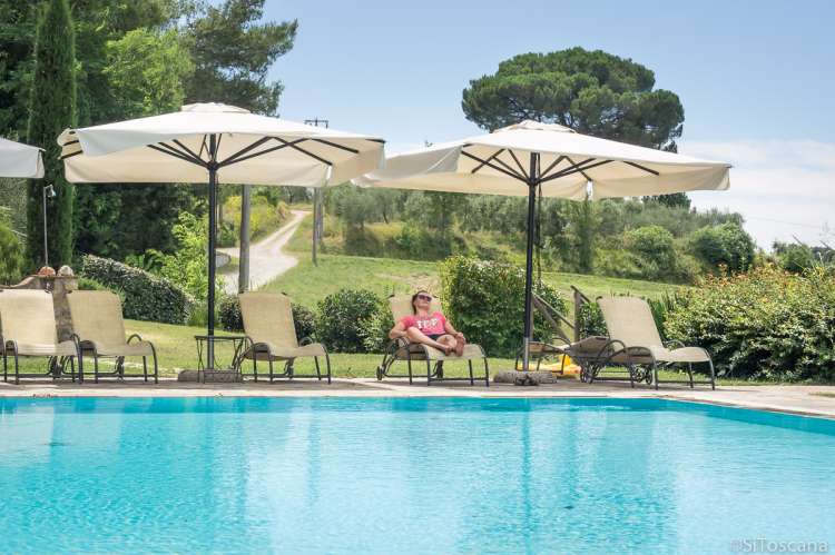 En fredelig stund ved bassenget. Bildet viser en feriegjest som har en fredelig stund ved bassenget på vingården.