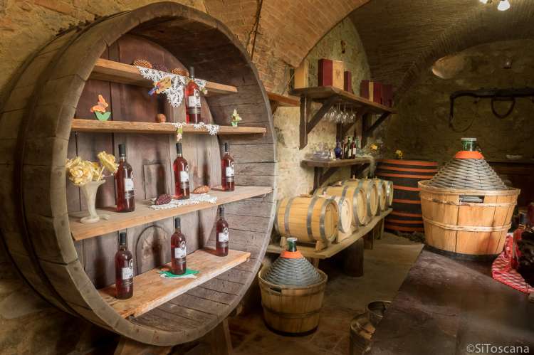 Fra vinkjelleren. På gården produseres både rødvin, hvitvin og rosèvin samt olivenolje.. Foto fra vinkjelleren på vingården. Vinflasker er utstilt med både rødvin, hvitvin og rosèvin.