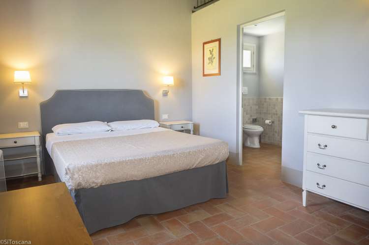 Bilde av soverom med dobbeltseng i ferieleiligheten Pinot Grigio. Dør direkte til badet.