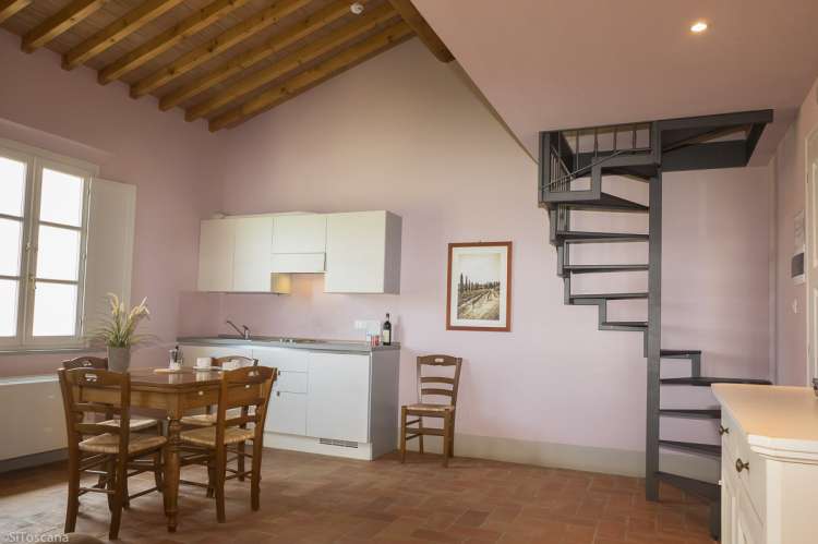 Bilde fra soverom med dobbeltseng og direkte dør til bad i ferieleiligheten Merlot på vingården Aldobrando.