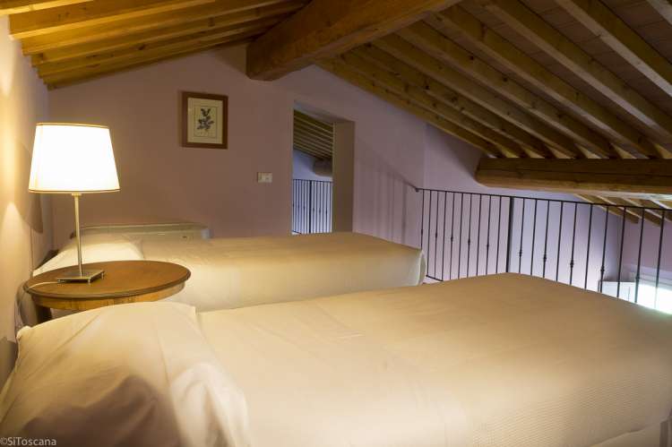 Bilde fra kjøkkenet med spisebord og sofra i ferieleiligheten Merlot på vingården Aldobrando.