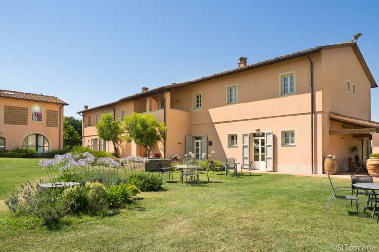 Foto av hovedbygningen med restaurant på vingården Aldobrando. Grøntarealer med boltreplass for barn.