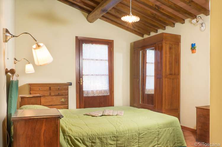 Bildet viser soverom med dobbeltseng i feriehuset Villa Noce i Toscana.