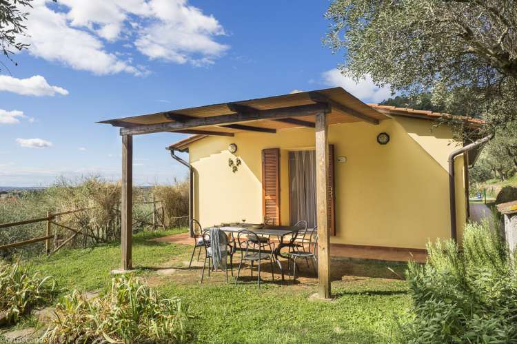 Bildet viser uteplass til Villa Noce, gressplen og blå himmel.