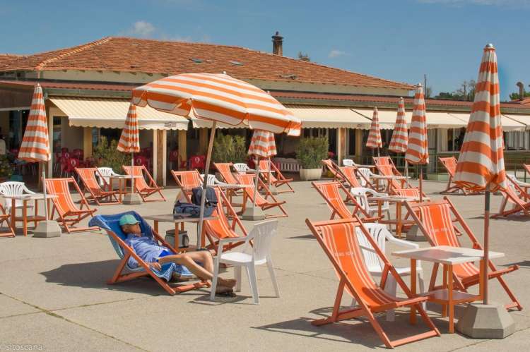 Bildet viser sandstrand med solstoler og parasoller ved feriehuset Buganvilla i Tirrenia.