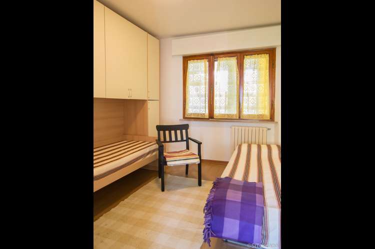 Bildet viser soverom med to enkeltsenger i ferieleiligheten Lorenzo ved havet i Tirrenia.