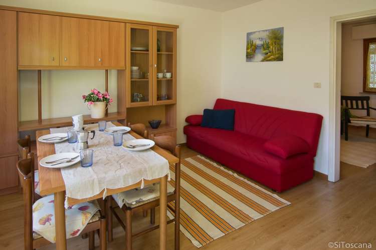 Bildet viser stue med sofa og spisebord i ferieleiligheten Lorenzo ved havet i Tirrenia.