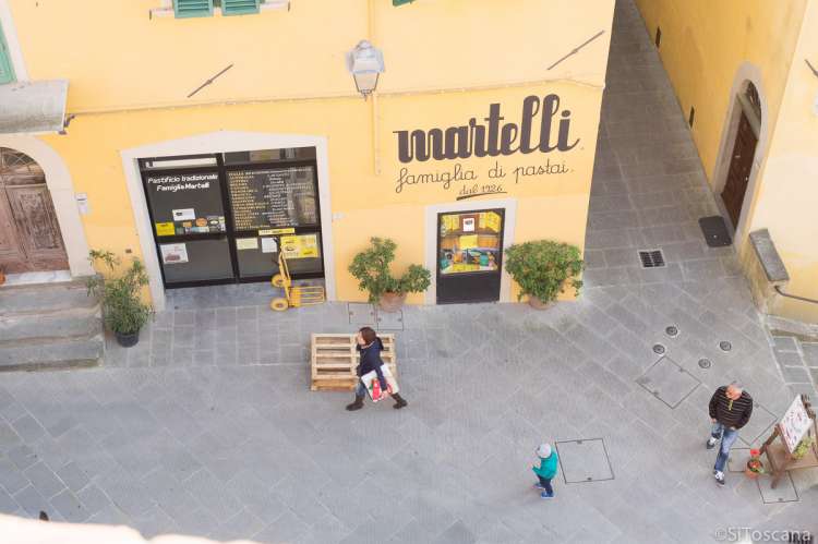 Bildet viser inngangen til den berømte pastafabrikken Martelli sett ovenfra middelalderborgen Castello dei Vicari. I gangavstand til feriebostedet La Pergola i Toscana. 