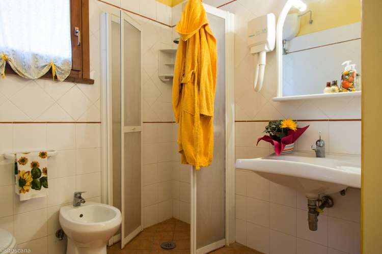 Bildet viser badet med dusj, toalett og servant i ferieleiligheten Limone. På feriebostedet La Pergola ved Pisa i Toscana.