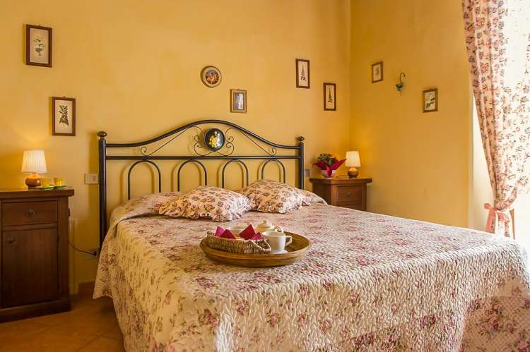 Bildet viser soverom med dobbeltseng i ferieleiligheten Mela. På feriebostedet La Pergola ved landsby i Toscana.