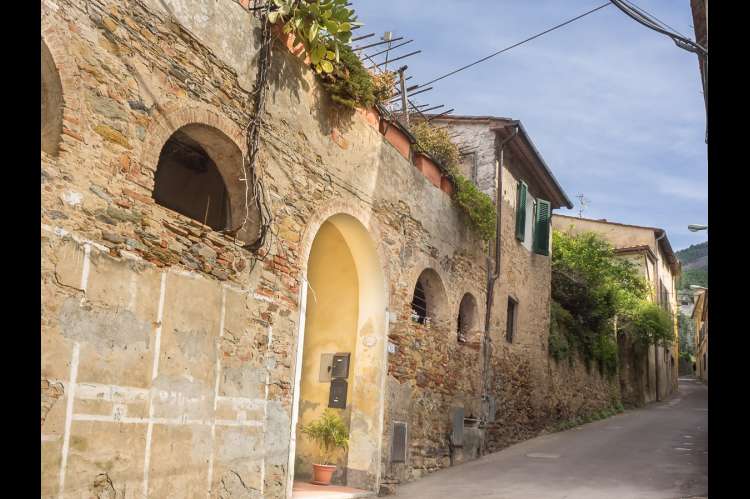 Foto av den smale landsbygata forbi ferieboligen. Typisk landsby i Toscana. Nært Pisa og kysten.
