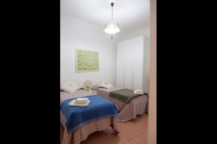 Foto av soverom med to enkeltsenger i ferieleiligheten Terrazza i Montemagno, rett utenfor Pisa.