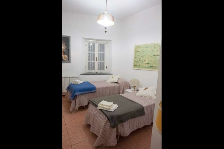 Foto av soverom med to enkeltsenger i ferieleiligheten Terrazza i Montemagno, rett utenfor Pisa. Vindu mot bakgården.