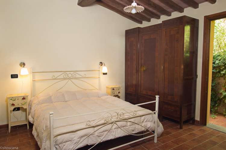 Bildet viser soverom med dobbeltseng og klesskap i feriehuset Villa Vista i Italia.