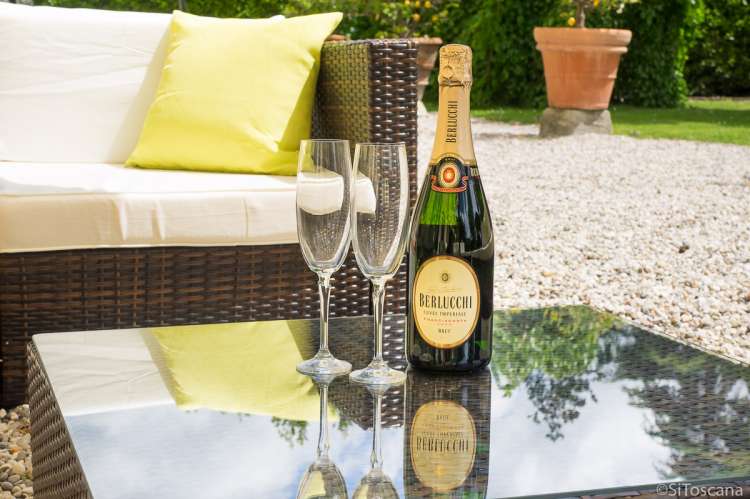 Bildet viser prosecco på terrassebord utenfor stor villa ved Pisa i Italia.