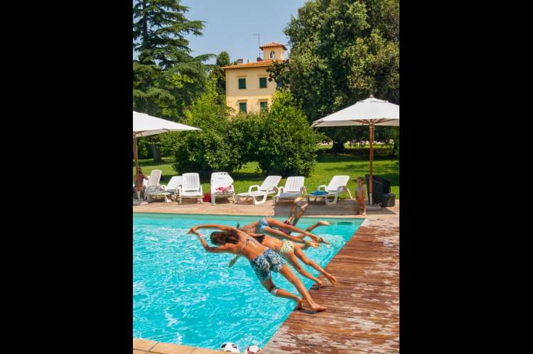Bildet viser barn som stuper i bassenget. Villa for storfamilien i Toscana.