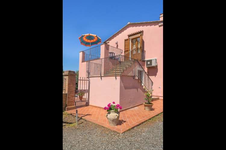 Bildet viser den solrike terrassen til ferieleiligheten Vinsanto på vingård i Toscana, Italia. 