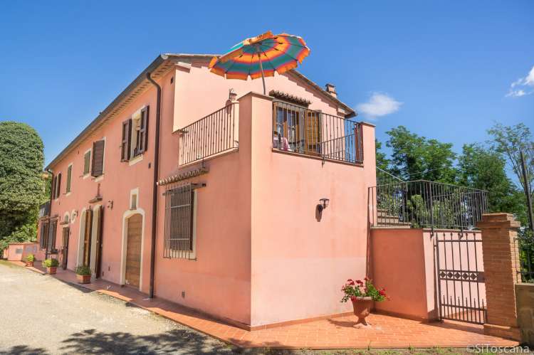 Foto fra veien utenfor feriehuset med inngang til ferieleiligheten Roscianello i Chianti.