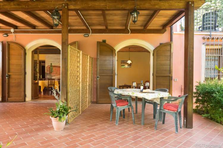 Foto viser uteplassen til ferieleiligheten Chianti med to soverom til høyre. Rommet for vinsmaking vises til venstre.