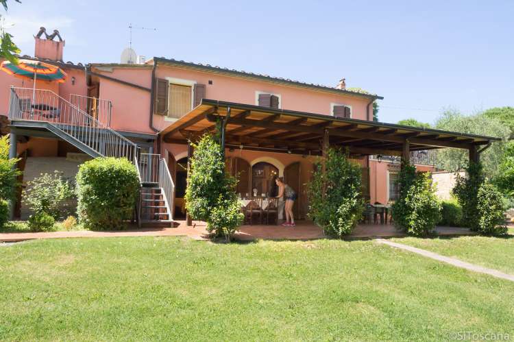 Feriehuset på vingården med terrasser og grønne plener. Foto.